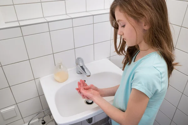 Девочка моет руки в раковине — стоковое фото