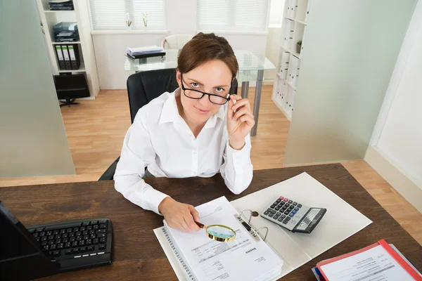 Femme d'affaires avec facture et loupe en verre — Photo