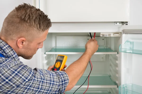 Técnico que verifica a geladeira com multímetro — Fotografia de Stock