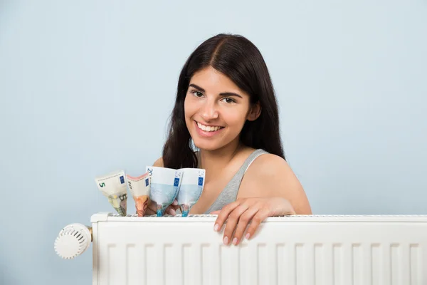 Mujer con billete dentro del radiador — Foto de Stock