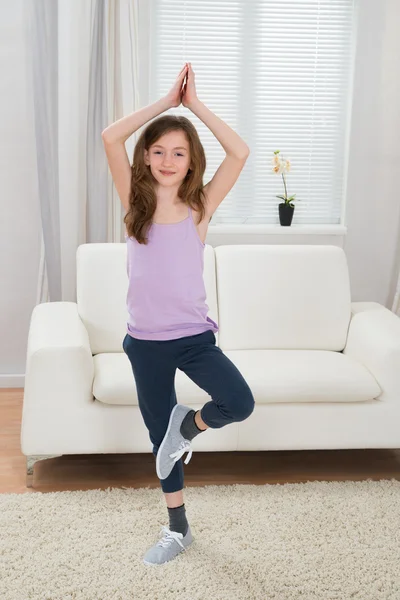 Menina fazendo ioga em casa — Fotografia de Stock