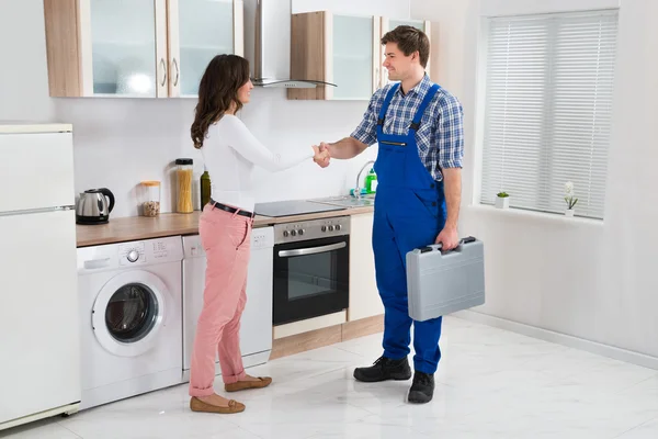 Reparateur schudden handen met vrouw — Stockfoto