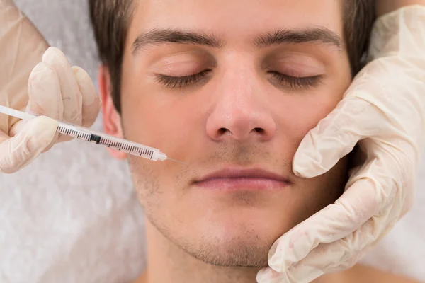 Läkare att ge injektion på vända mot av Man — Stockfoto