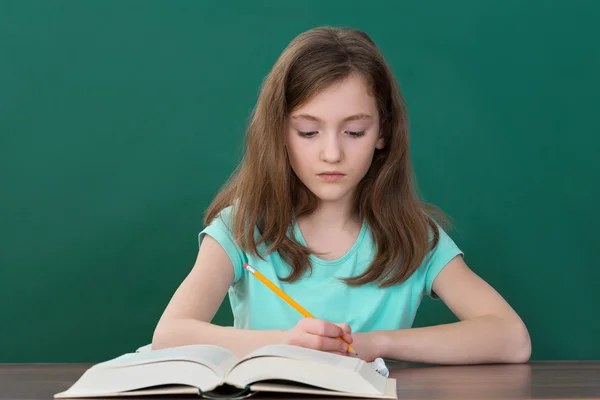 Menina leitura livros na sala de aula — Fotografia de Stock