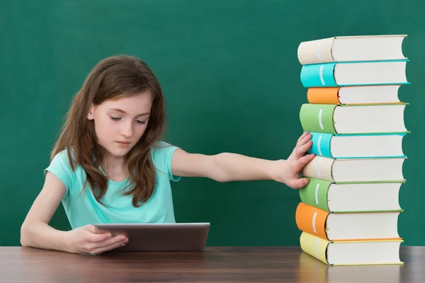 Menina usando tablet digital e evitando livros — Fotografia de Stock