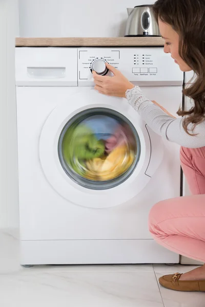 Frau drückt Taste der Waschmaschine — Stockfoto