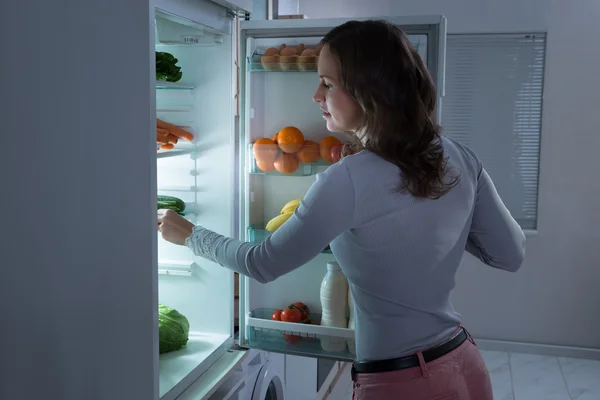 Mujer buscando comida en el refrigerador — Foto de Stock