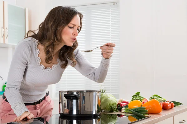 Jovem mulher degustação de alimentos — Fotografia de Stock