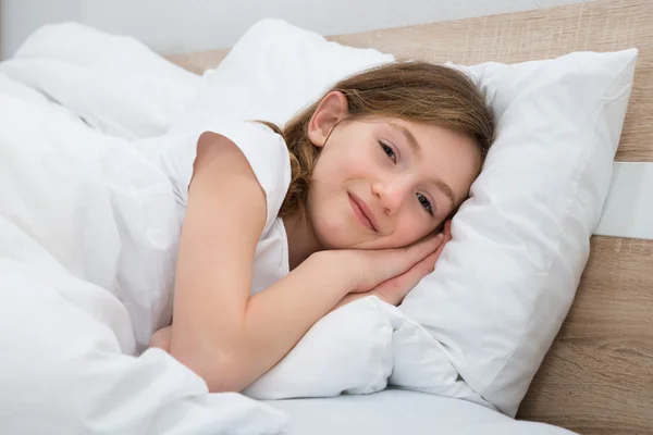 Chica feliz acostada en la cama — Foto de Stock