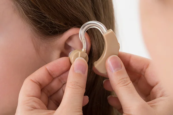 Doctor Inserting Hearing Aid In The Ear Of A Girl — Stock Photo, Image