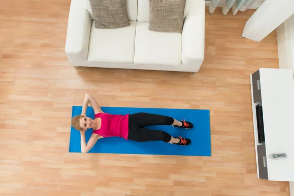 Mujer feliz haciendo ejercicio en casa — Foto de Stock