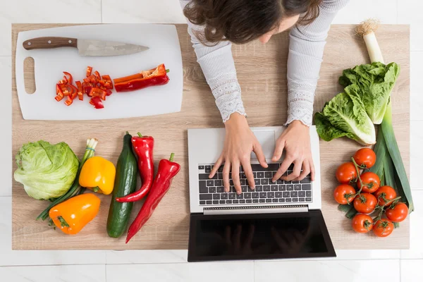 Mujer usando portátil en la cocina —  Fotos de Stock