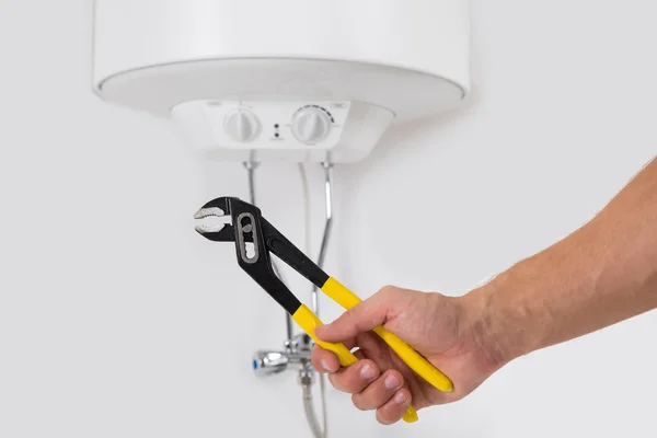 Hands With Wrench In Front Of Electric Boiler — Stock Photo, Image