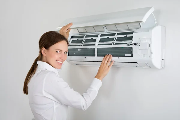 Affärskvinna kontrollera Air Conditioner — Stockfoto
