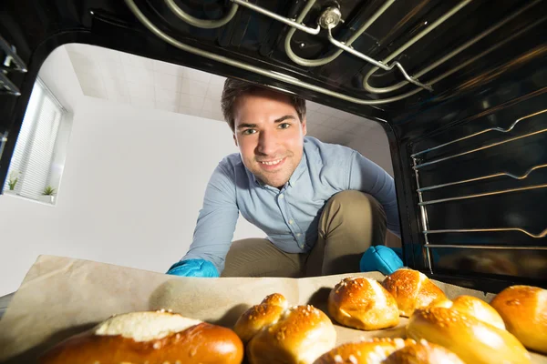 Uomo prendendo fuori pane vista da dentro il forno — Foto Stock