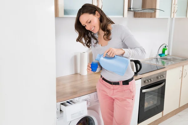 Mulher derramando detergente líquido — Fotografia de Stock