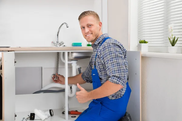 Klempner repariert Wasserhahn in Küche — Stockfoto