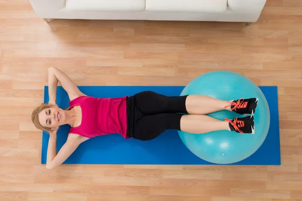 Mujer haciendo ejercicio con pelota de pilates — Foto de Stock