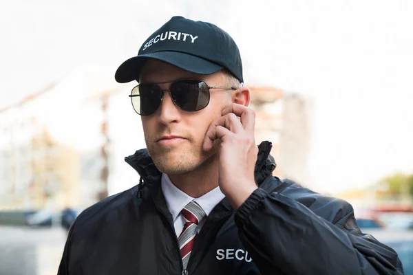 Security Guard luisteren naar luistergedeelte — Stockfoto