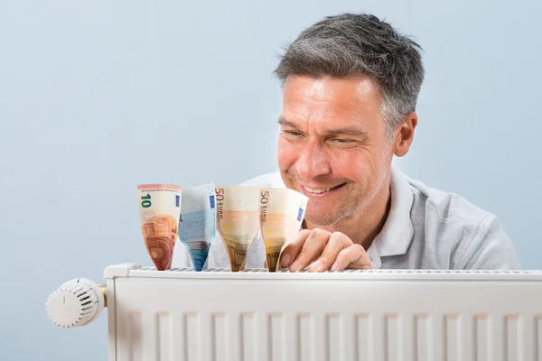 Man brengen van eurobiljetten op Radiator — Stockfoto