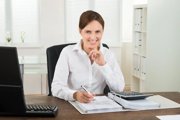 Businesswoman Calculating Invoice Stock Image