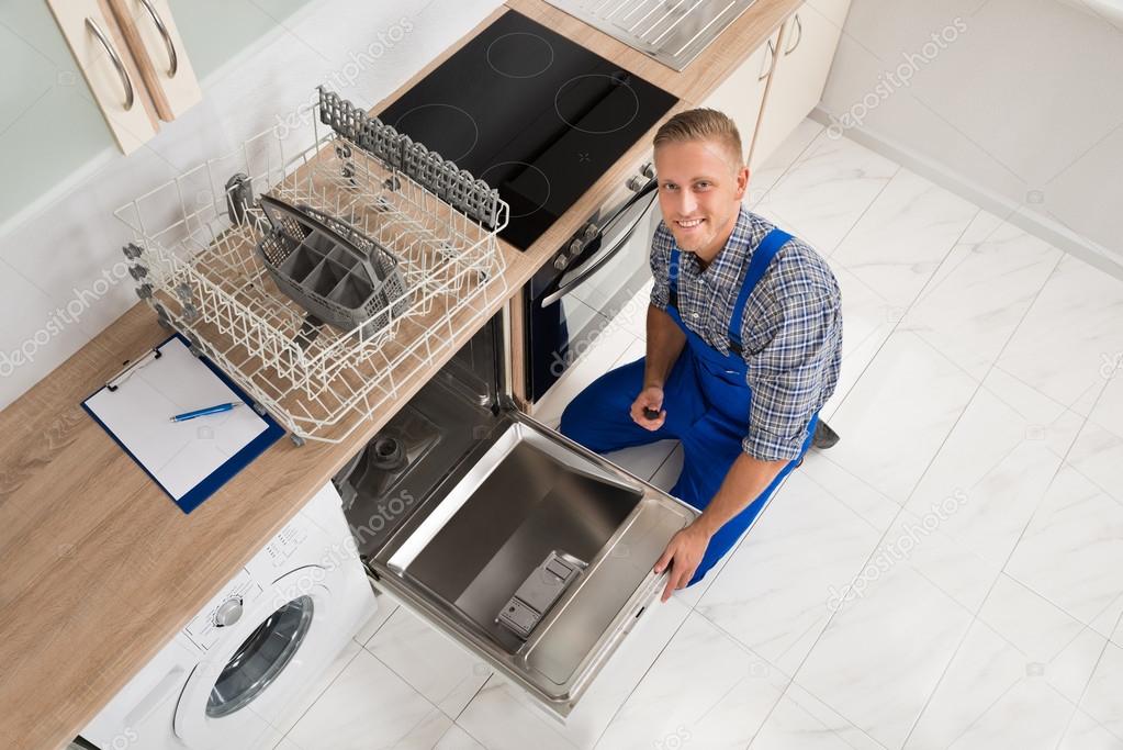 Worker With Toolbox Repairing Dishwasher