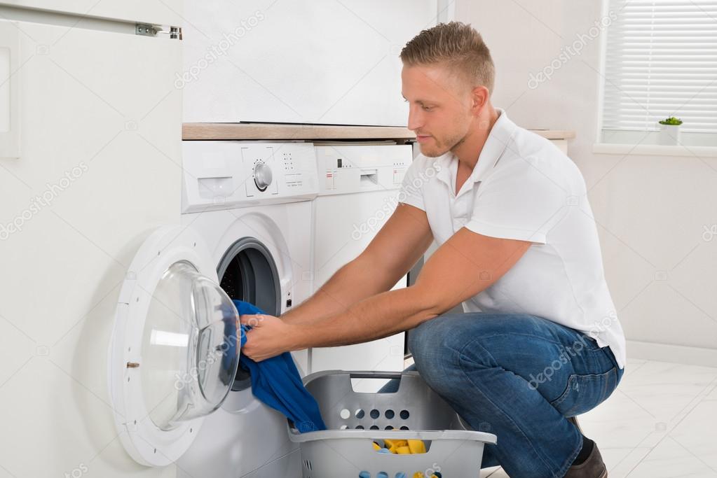Man Loading Washing Machine With Clothes