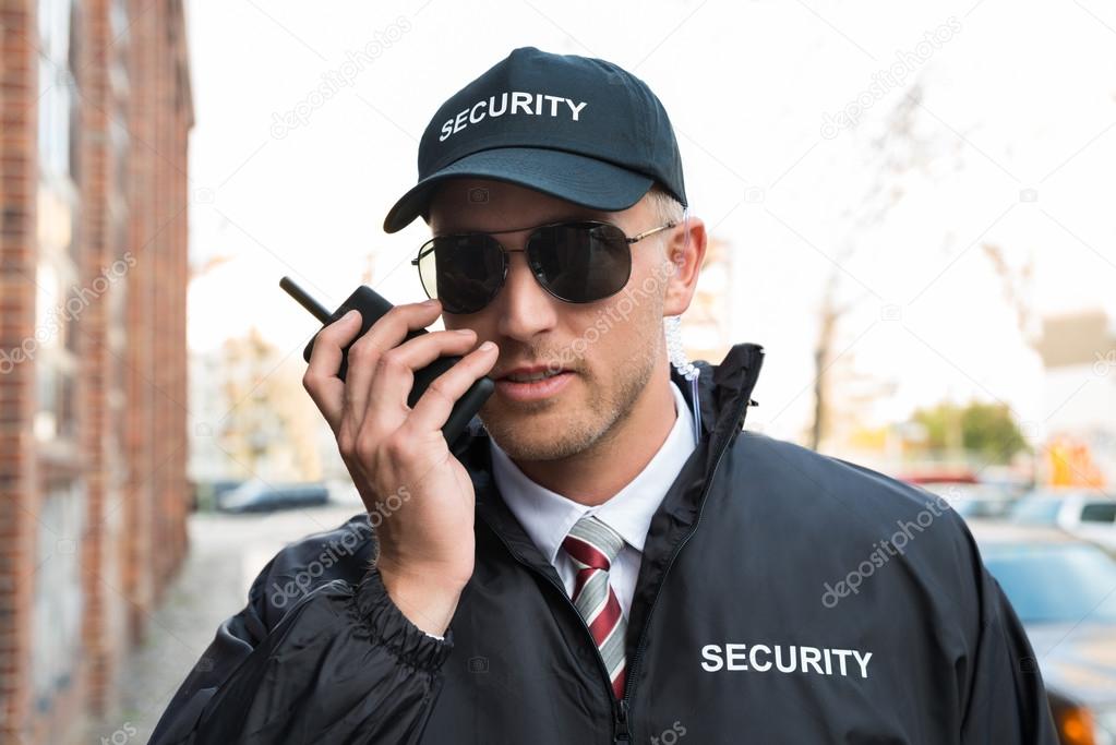 Security Guard Talking On Walkie-talkie
