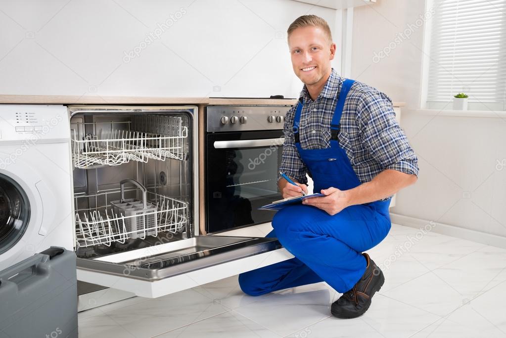 Handyman With Clipboard Looking At Dishwasher