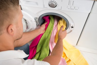 Havlu çamaşır makinesine yükleme adam
