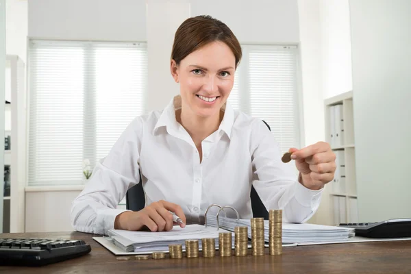 Mujer de negocios Colocación de monedas a pila de monedas — Foto de Stock