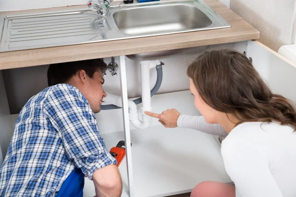 Woman Showing Damage In Sink Pipe — Stock Photo, Image