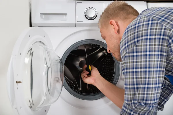 Trabalhador fixando máquina de lavar roupa — Fotografia de Stock