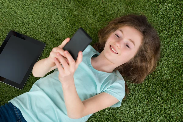 Boldog lány digitális tábla és a mobil telefon — Stock Fotó