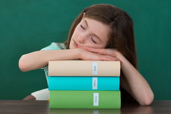 Chica con libros durmiendo en el escritorio —  Fotos de Stock