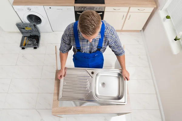 Klempner befestigt Waschbecken aus Edelstahl — Stockfoto