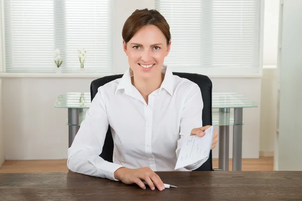 Geschäftsfrau bietet Scheck im Amt an — Stockfoto