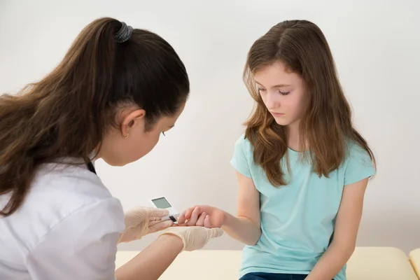 Médico medir o nível de açúcar no sangue da menina — Fotografia de Stock