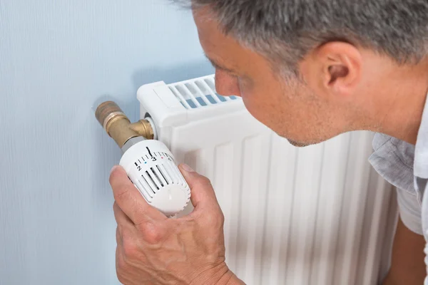 Homme utilisant le radiateur — Photo