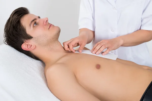 Terapeuta de beleza encerando o peito do homem — Fotografia de Stock