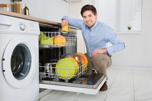 Hombre Arreglando platos en lavavajillas — Foto de Stock