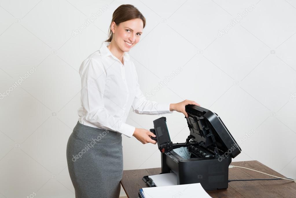 Businesswoman Holding Laser Cartridge With Printer