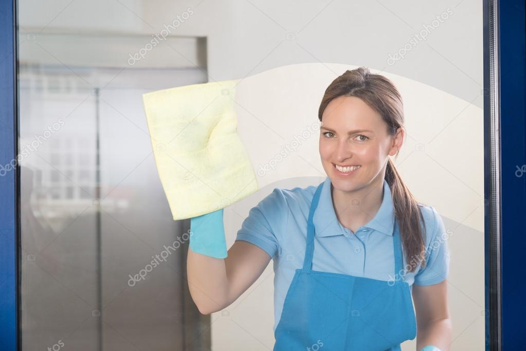 Female Janitor Cleaning Glass