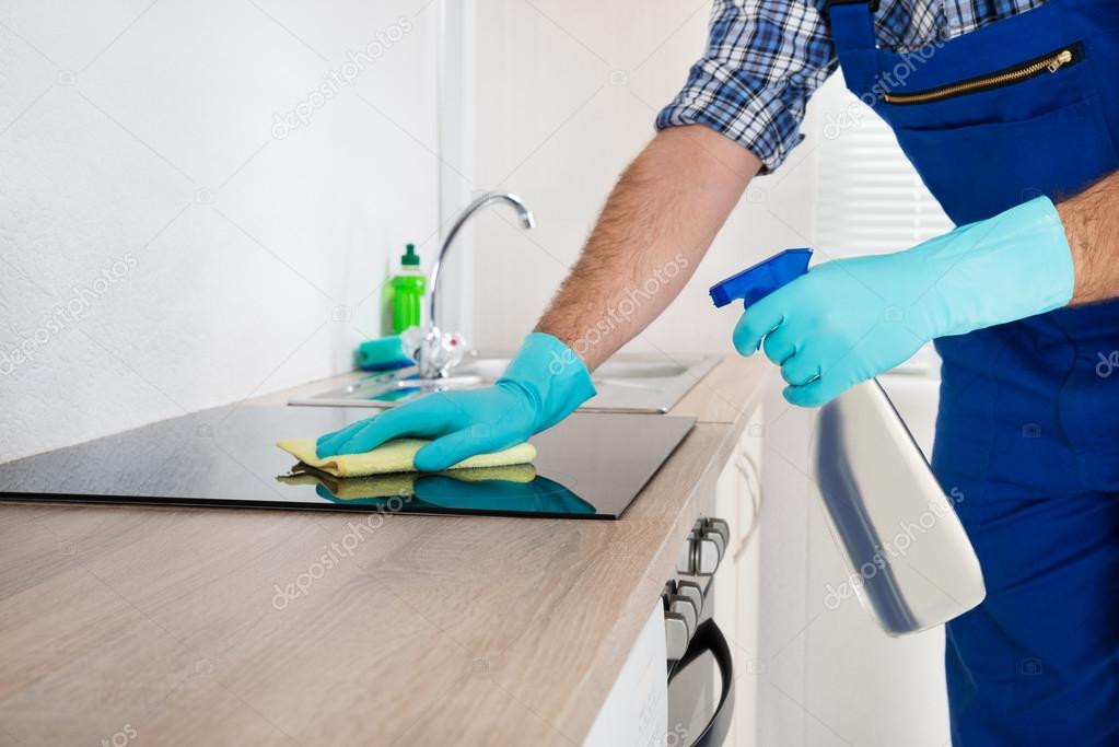 Worker Cleaning Electric Hob