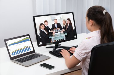 Businesswoman Videoconferencing With Colleagues clipart