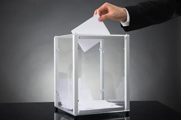Geschäftsmann wirft Stimmzettel in Urne — Stockfoto