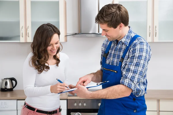 Vrouw schrijven op Klembord met loodgieter — Stockfoto