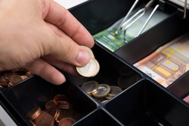 Person Hand Putting Coins In Cash Register clipart