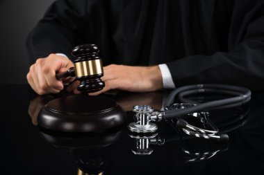 Judge Hitting Gavel With Stethoscope clipart