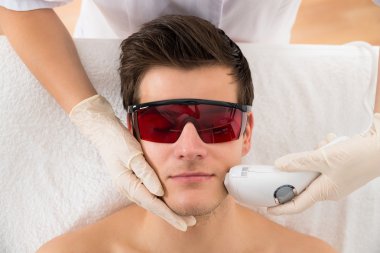 Beautician Giving Laser Epilation Treatment clipart